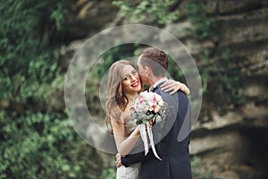 Just married wedding couple posing and bride holding in hands bouquet