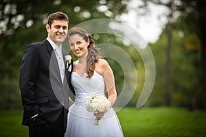 Just married, young wedding couple in a park