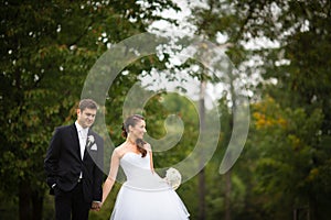 Just married, young wedding couple in a park