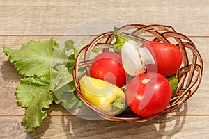 Just picked tomatoes and yellow bell pepper in a wicker basket w