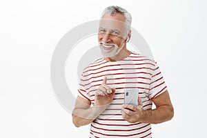 Just sec wanna hear chorus. Charming happy and charismatic mature man with grey hair and beard in striped t-shirt