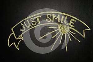 Just smile with Ribbon Banner, written with chalk on a blackboard