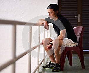 Just a spectator today. a handsome young man watching a game of squash.