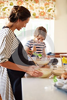 Just a touch now. a little girl baking with her mother in the kitchen.