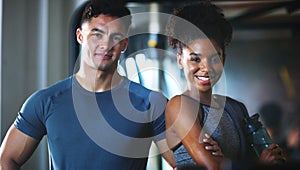 Just two fitness fanatics. Portrait of two sporty young people at the gym.