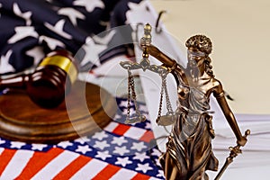 Justice holding the scales of justice with unfinished documents on law office table on American flag Legal office