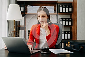 justice and law concept. Female judge in a courtroom the gavel, working with smart phone and laptop and digital tablet computer