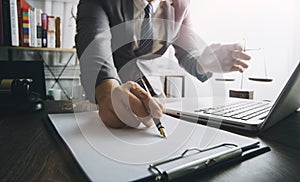 Justice and law concept.Male judge in a courtroom with the gavel, working with, computer and docking keyboard, eyeglasses, on