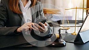 Justice and law concept.Male judge in a courtroom  the gavel, working with smart phone and laptop and digital tablet computer on