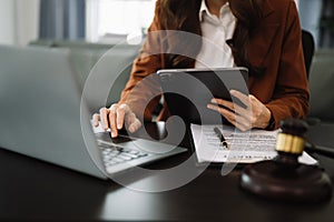 justice and law concept.Male judge in a courtroom the gavel, working with smart phone and laptop and digital tablet computer on