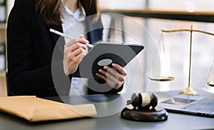 justice and law concept.Male judge in a courtroom the gavel, working with smart phone and laptop and digital tablet computer on