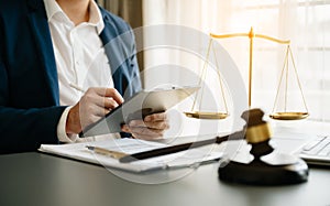 justice and law concept.Male judge in a courtroom the gavel, working with smart phone and laptop and digital tablet computer on