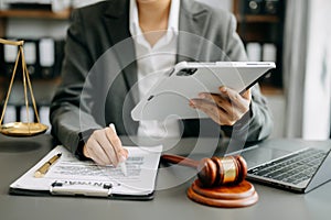 justice and law concept. Male judge in a courtroom the gavel, working with smart phone and laptop and digital tablet computer on