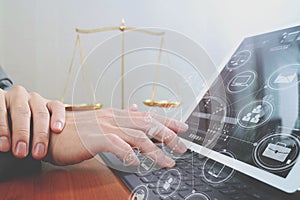 justice and law concept.Male lawyer in office with the gavel,working with smart phone and digital tablet computer and brass scale