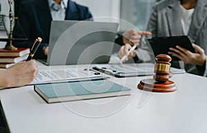 Justice and law concept. Team judge in a courtroom the gavel, working with digital tablet computer on table in sun light