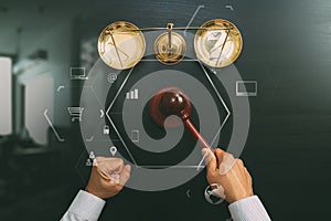 justice and law concept.Top view of Male judge hand in a courtroom with the gavel and brass scale on dark wood table with