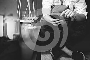 Justice and Law context.Male lawyer hand sitting on sofa and working with smart phone,digital tablet computer docking keyboard wi