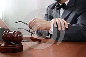 Justice and Law context.Male lawyer hand working with smart phone,digital tablet computer docking keyboard with gavel and