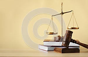 Justice scales, judge`s gavel and books on table against beige background