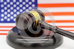 Justice Under the Stars and Stripes. A judgeâ€™s gavel rests on a sound block against the backdrop of an American flag,