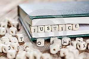 Justice word written on a wooden block.