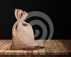 Jute coffee bag and beans isolated on the wood background