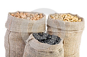 Jute sacks with dried peas, soja beans and black legume photo