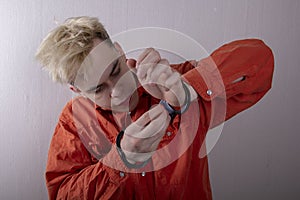 A juvenile delinquent tries to open the handcuffs with a paper clip.concept: attempt to escape from custody, opening locks, violat photo