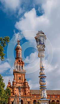 Juxtaposition of blue and white ceramic azulejo tiles against one of the baroque sandstone tower at Plaza de Espana in Seville, Sp