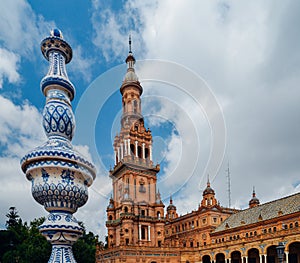 Juxtaposition of blue and white ceramic azulejo tiles against one of the baroque sandstone tower at Plaza de Espana in Seville, Sp photo