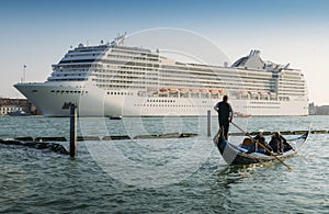 Juxtaposition of gondola and huge cruise ship in Giudecca Canal. Old and new transportation on the Venice Lagoon
