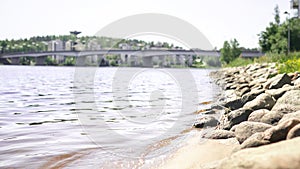 Jyvaskyla, Finland. Lake and the bridge of Kuokkala. Waves hitting rocks. Beautiful Finnish nature. Sunny summer landscape.