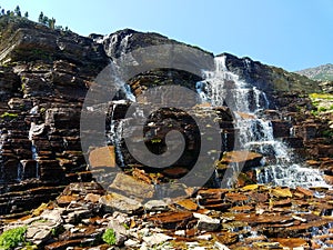 4k Amazing Rocky Mountain glacier stream waterfall in the summer with flowers