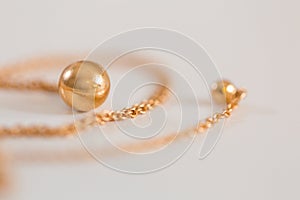 18K golden ball necklace on white closeup