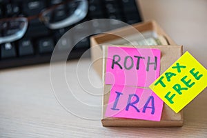 401k ira roth on pieces of colorful paper dollars on table. Pension concept. Retirement plans