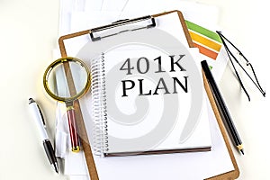 401 K PLAN text on notebook with clipboard on white background