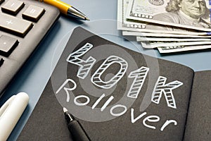 401k rollover memo on the notepad and cash. photo