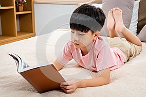 9-year-old Asian boy sitting and reading a book With pleasure, he readily reviewed the things he had learned each day in his bed photo