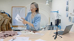 4K Young woman working in a clothing store. The designer shoots his work on the phone camera