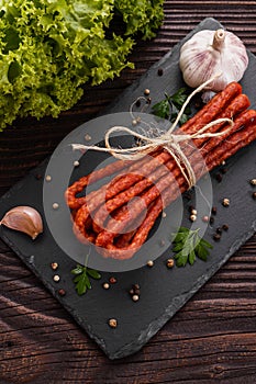 Kabanos delicious polish snack sausage on a stone plate wooden background