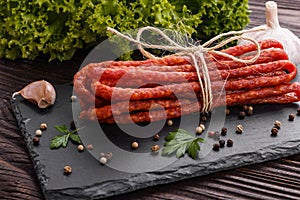 Kabanos delicious polish snack sausage on a stone plate wooden background