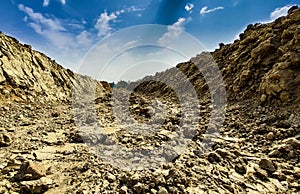 A kaccha valley road of rocky soil in the summer heat