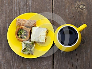 Kadaif and baklava on a yellow saucer and morning coffee