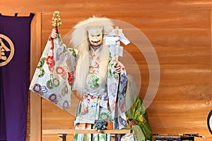 Kagura dance performed by the Inari fox deity holding suzu bells and a gohei wand.