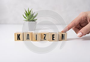 Kaizen improvement sign made of blocks on a wooden desk in a bright room