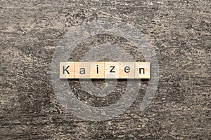 kaizen word written on wood block. kaizen text on table, concept