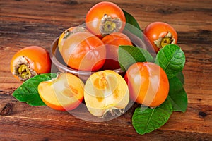 Kaki or persimmon fruits on old wooden background photo