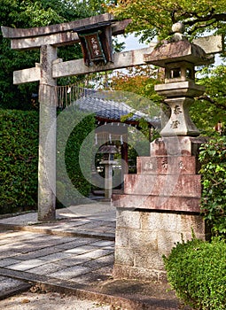 A kaku-doro  square stone lantern with the torii gate in the Japanese shrine. Kyoto. Japan