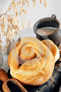 Kalach is a round white wheat homemade bread. Close-up of white bread with soy milk and homemade black salt. Close-up