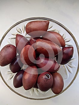 Kalamata olives in a glass bowl on a white background top view